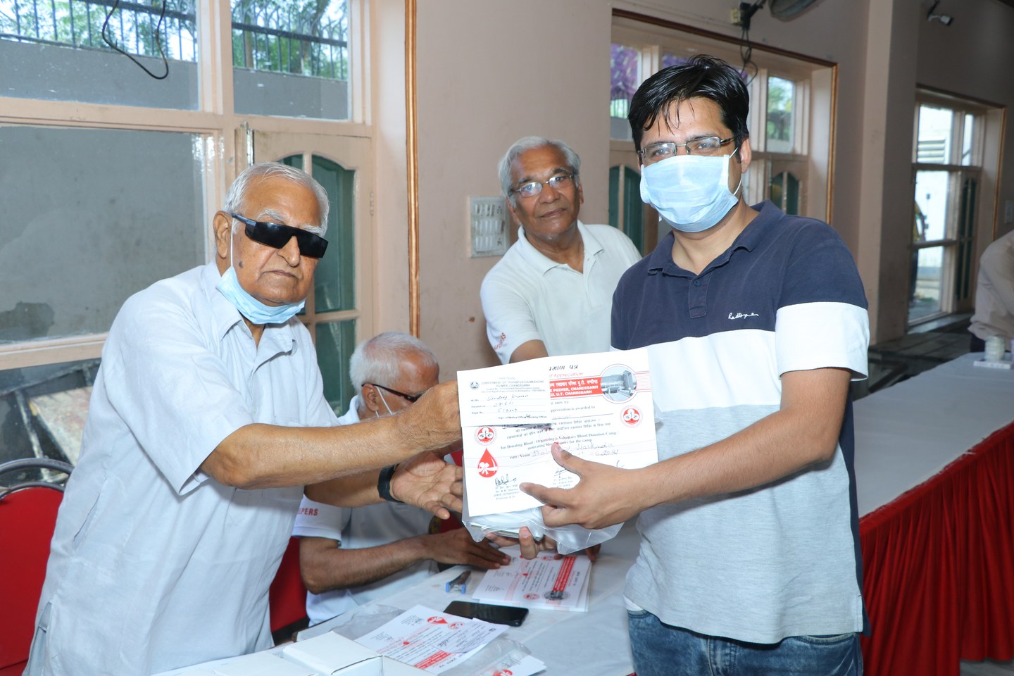 Voluntary blood donor resting comfortably with appreciation certificate